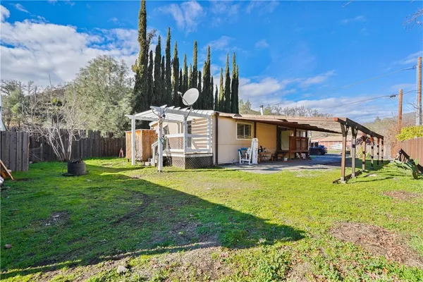 a view of a house with backyard and a tree