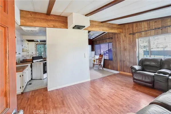 a living room with stainless steel appliances furniture and a kitchen view