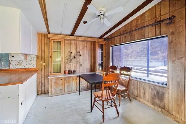 a dining room with furniture and large windows