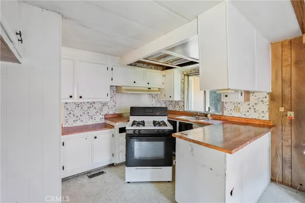 a kitchen with a stove sink and cabinets