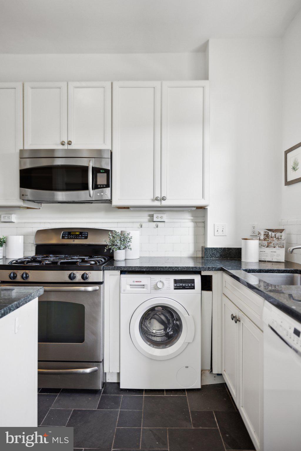 1852 Columbia Road Northwest, Unit 503 Washington, DC 20009 - Photo 14 of 32 a kitchen with cabinets stainless steel appliances and a sink