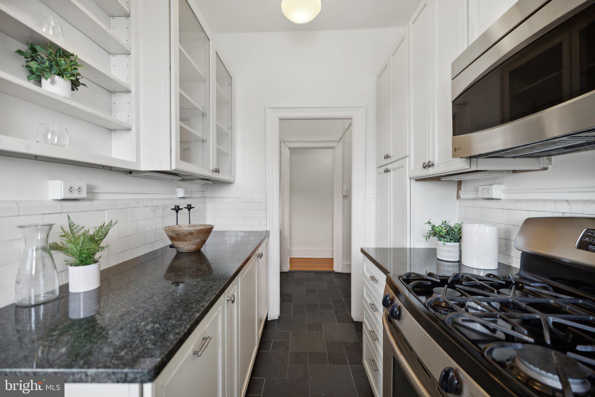 1852 Columbia Road Northwest, Unit 503 Washington, DC 20009 - Photo 16 of 32 a kitchen with stainless steel appliances granite countertop a stove a sink and a granite counter tops