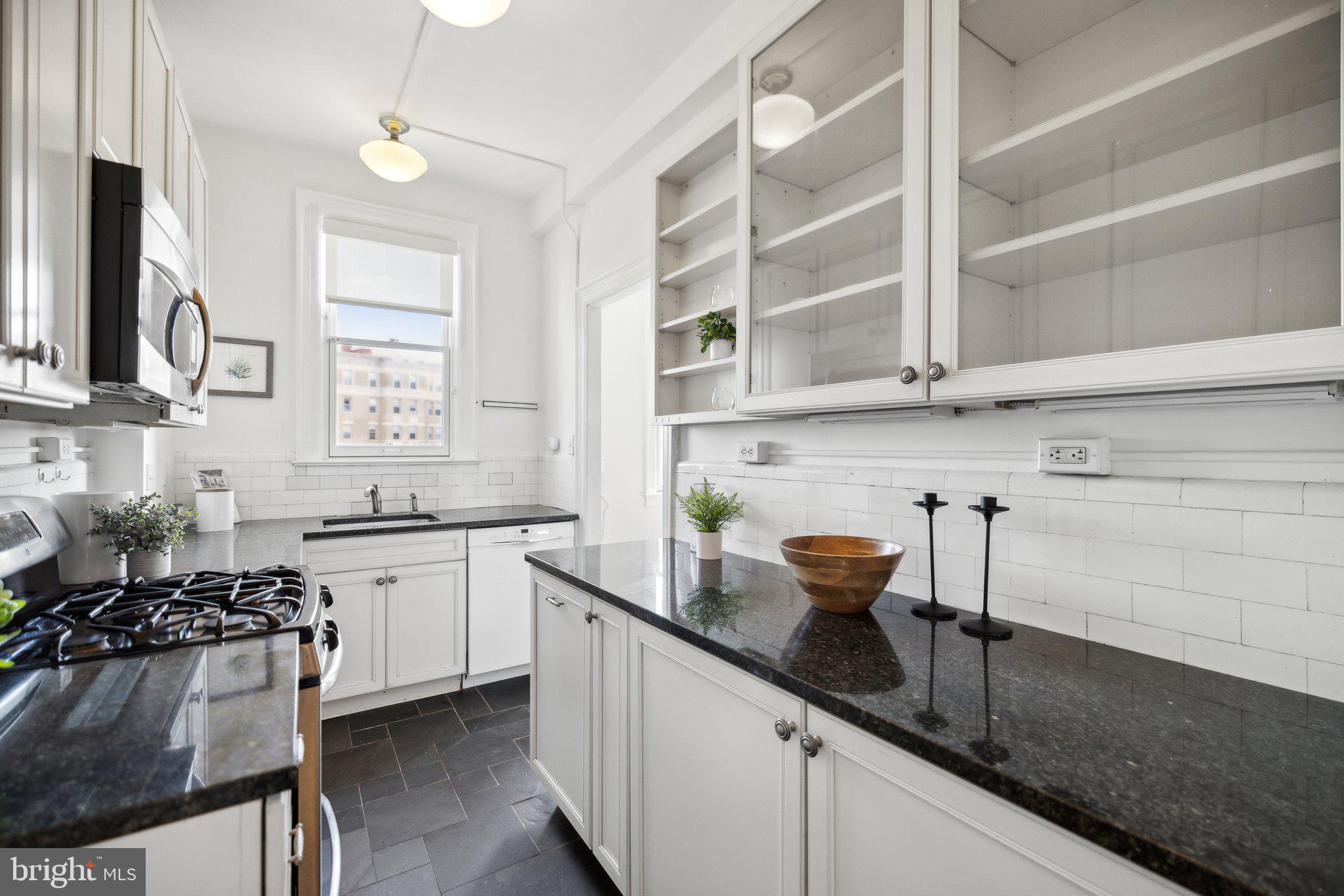 1852 Columbia Road Northwest, Unit 503 Washington, DC 20009 - Photo 17 of 32 a kitchen with stainless steel appliances granite countertop a sink stove and cabinets