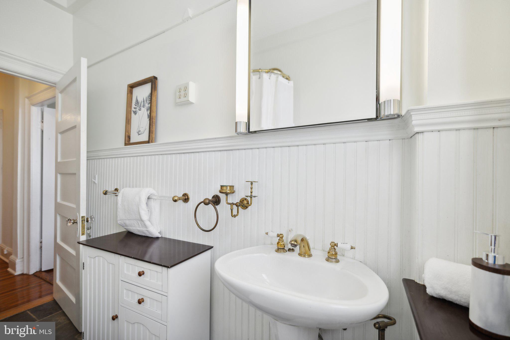 1852 Columbia Road Northwest, Unit 503 Washington, DC 20009 - Photo 28 of 32 a bathroom with a granite countertop sink and a mirror