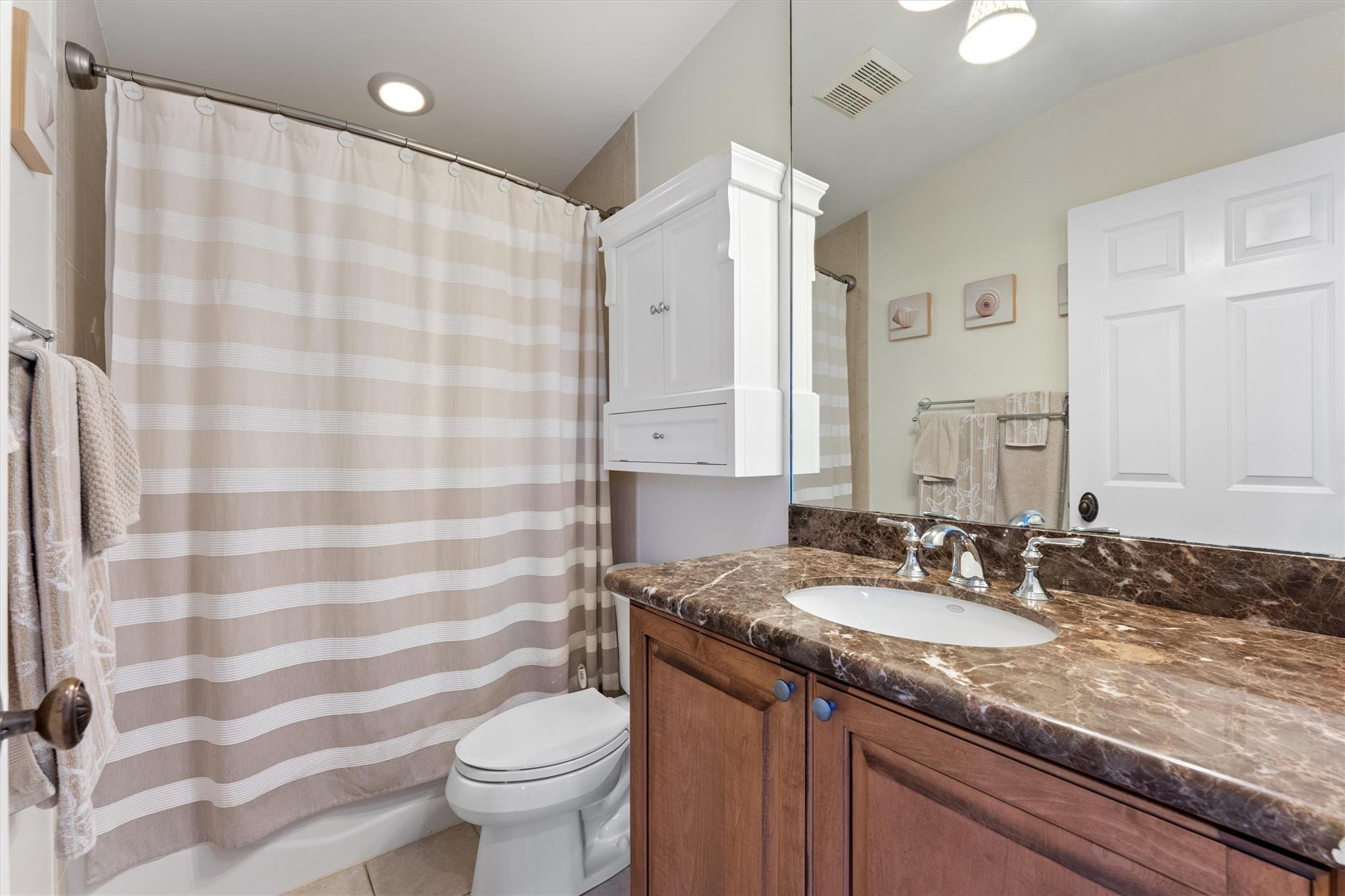950 Southwest 7th Street, Unit 950 Fort Lauderdale, FL 33315 - Photo 27 of 42 a bathroom with a granite countertop sink a toilet a mirror and shower curtain