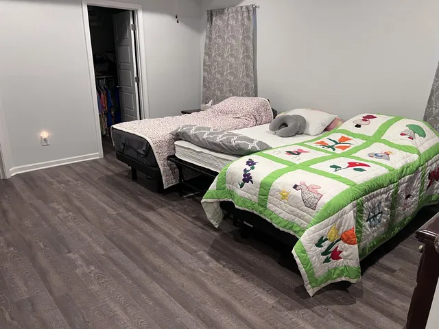 a bedroom with two beds and a wooden floor