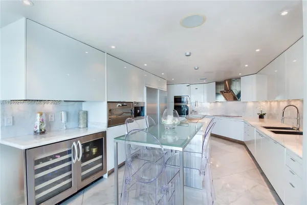 a large kitchen with stainless steel appliances granite countertop a sink and cabinets