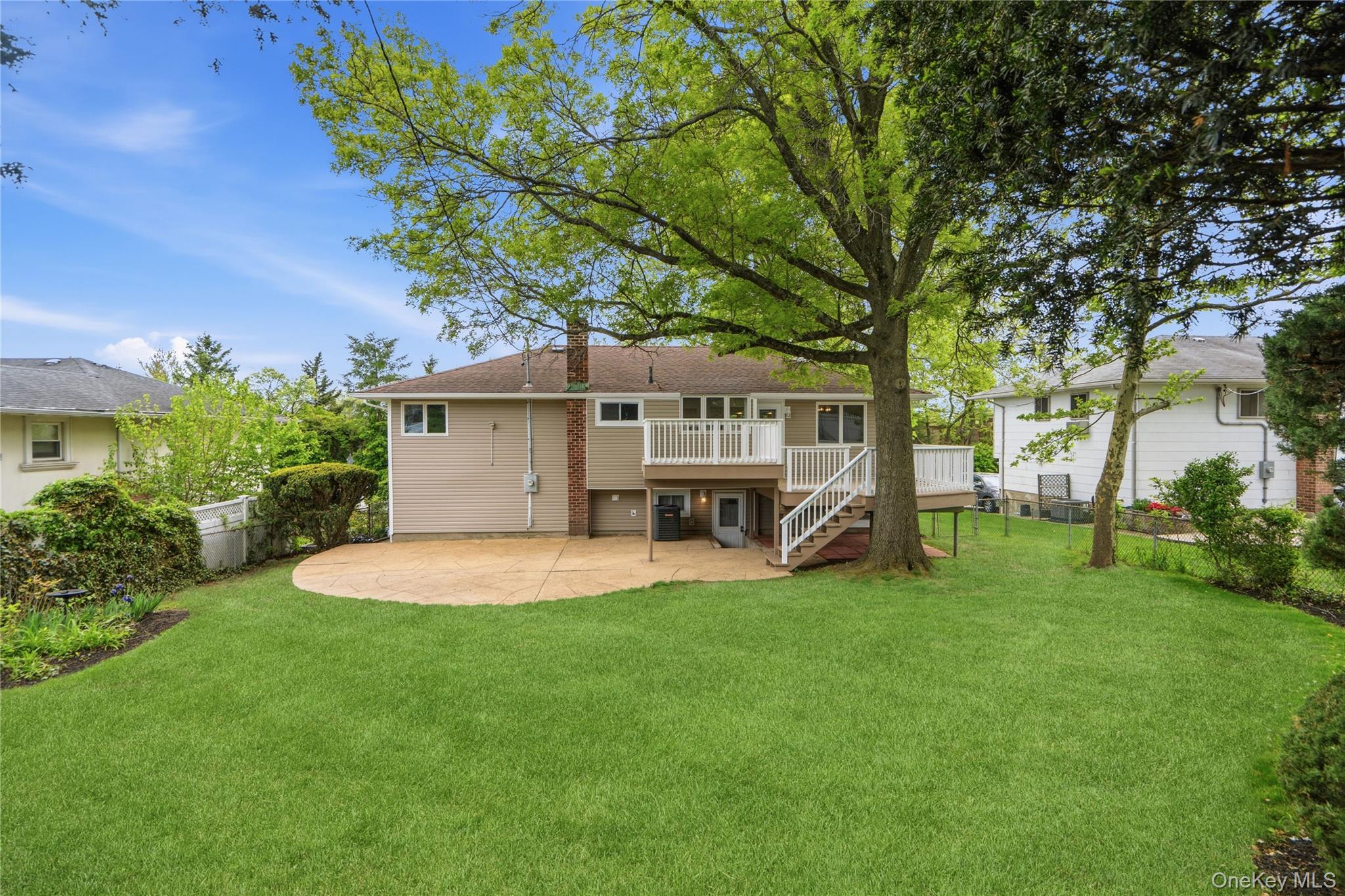 183 North Marginal Road Jericho, NY 11753 - Photo 25 of 28 Expansive green lawn with mature trees, patio, a new multi-level wood deck, and an exterior with siding and brick accents