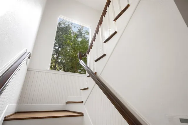 a view of staircase with railing and white walls