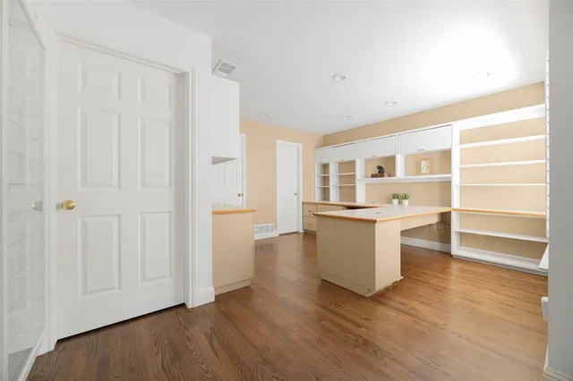 a view of a kitchen with wooden floor and a window