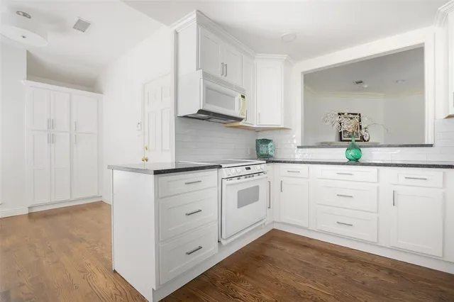 a kitchen with white cabinets and white appliances