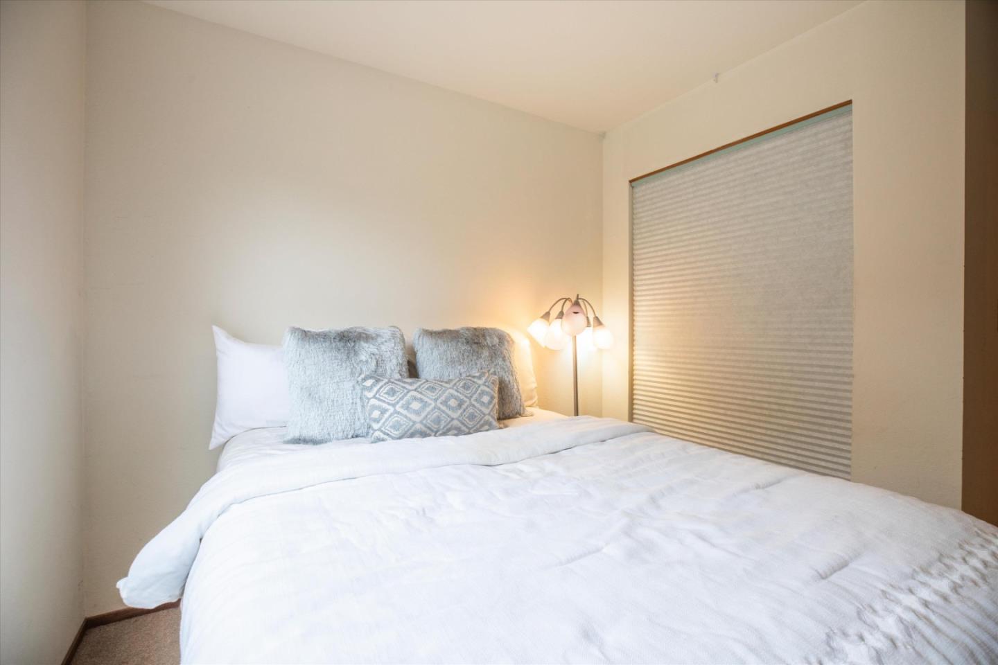 6333 Tustin Road Salinas, CA 93907 - Photo 29 of 88 a large white bed in a bedroom next to a window and a lamp