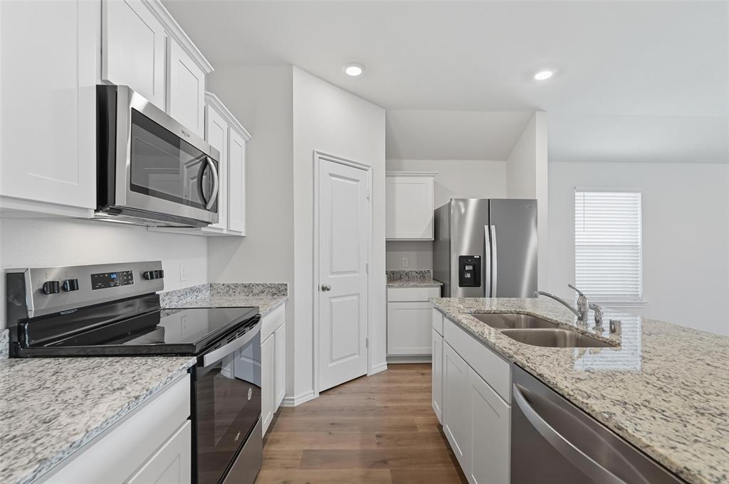 110 Labein Avenue Greenville, TX 75402 - Photo 5 of 20 a kitchen with stainless steel appliances granite countertop a sink stove and refrigerator