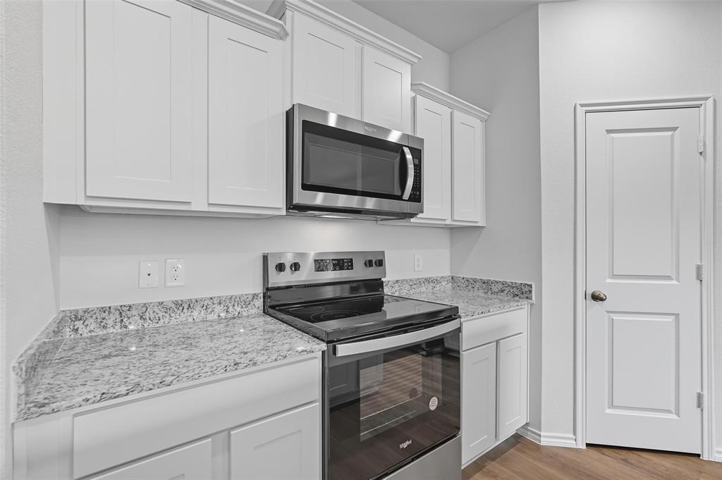 110 Labein Avenue Greenville, TX 75402 - Photo 7 of 20 a kitchen with stainless steel appliances granite countertop white cabinets and a stove top oven