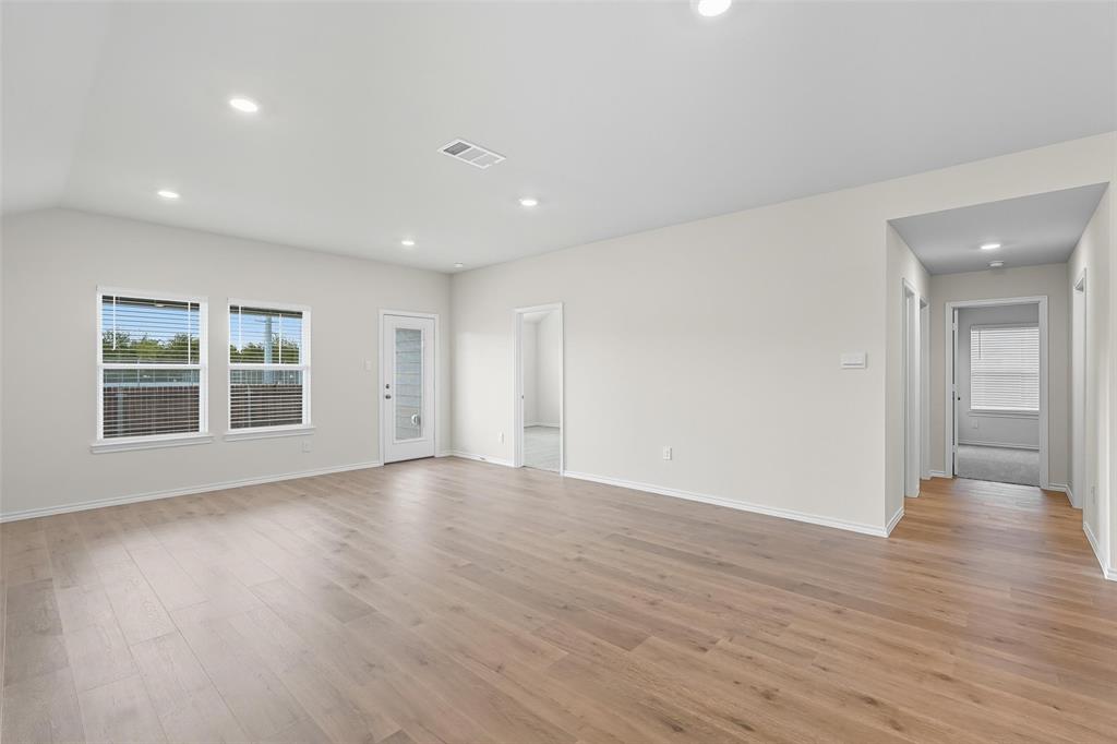 110 Labein Avenue Greenville, TX 75402 - Photo 8 of 20 a view of an empty room with wooden floor and windows