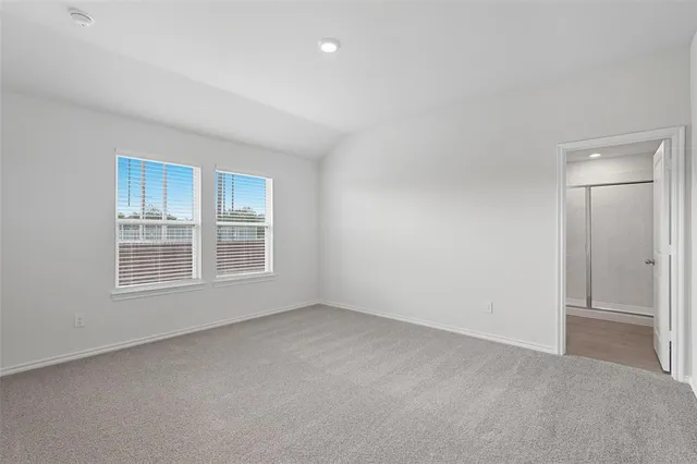 a view of an empty room with wooden floor and windows