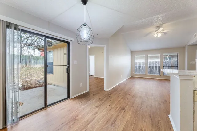 a kitchen with wooden floors and white cabinets