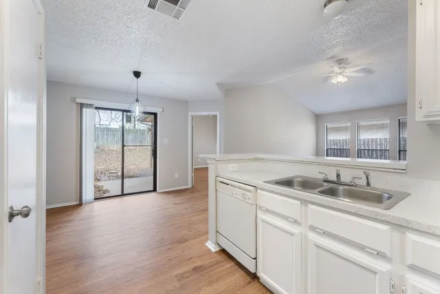 a kitchen with cabinets wooden floor and a sink