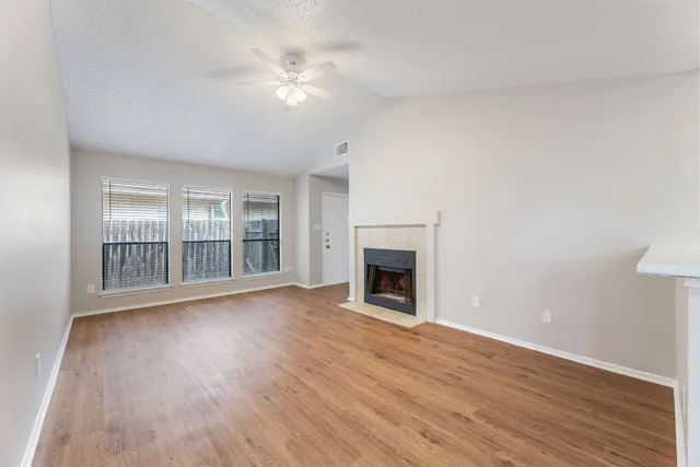 a view of empty room with wooden floor and fireplace