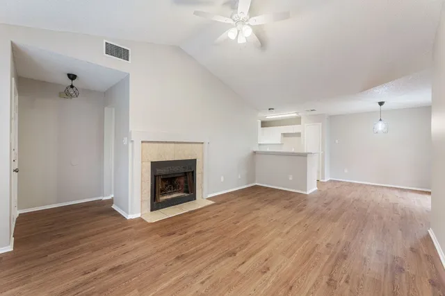 wooden floor fireplace and windows in an empty room
