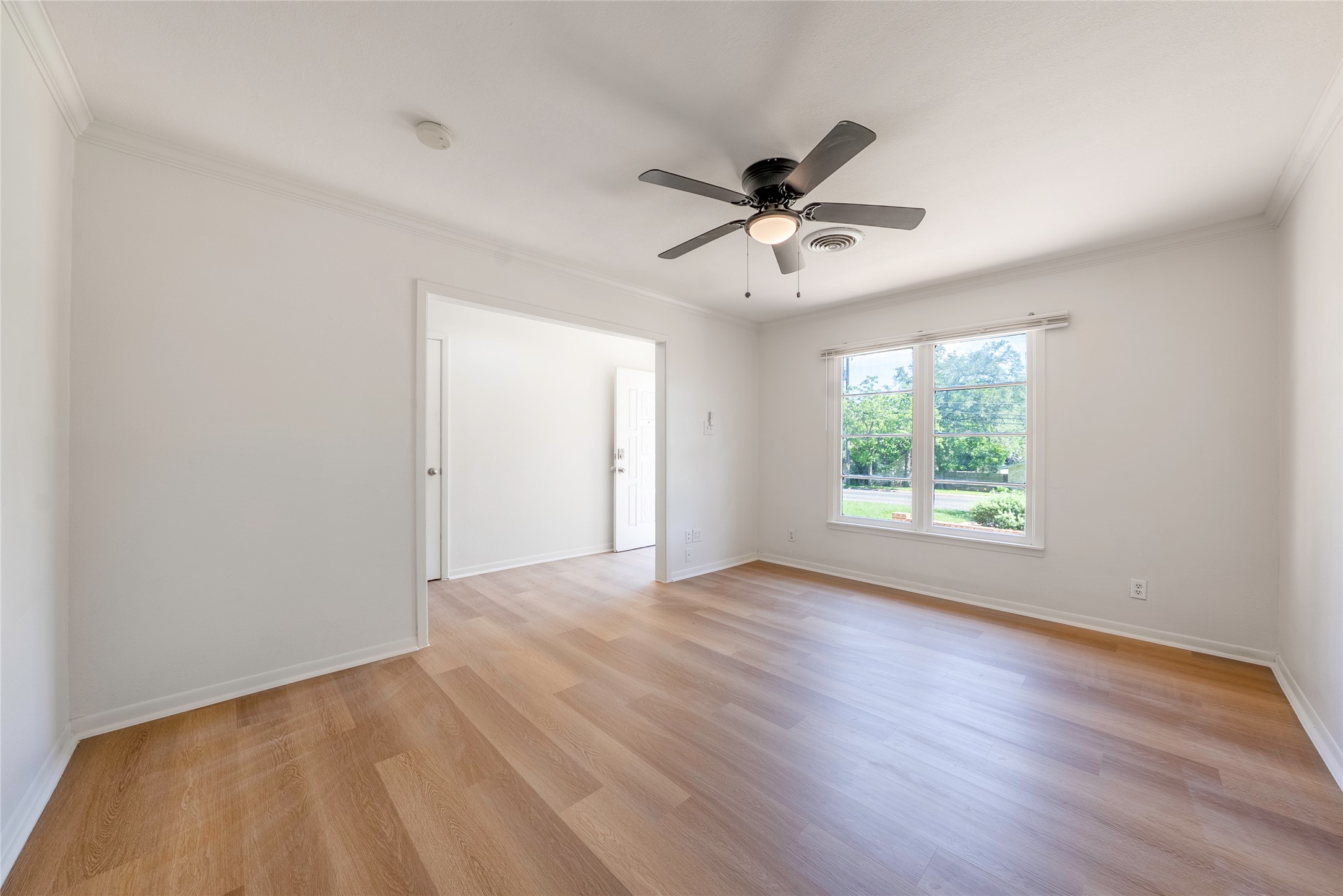 807 Country Club Road Georgetown, TX 78628 - Photo 3 of 28 an empty room with wooden floor fan and windows