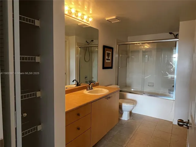 a bathroom with a granite countertop sink toilet mirror and bathtub