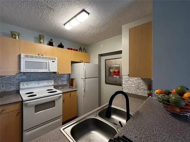 a kitchen with a appliances a refrigerator and a stove top oven