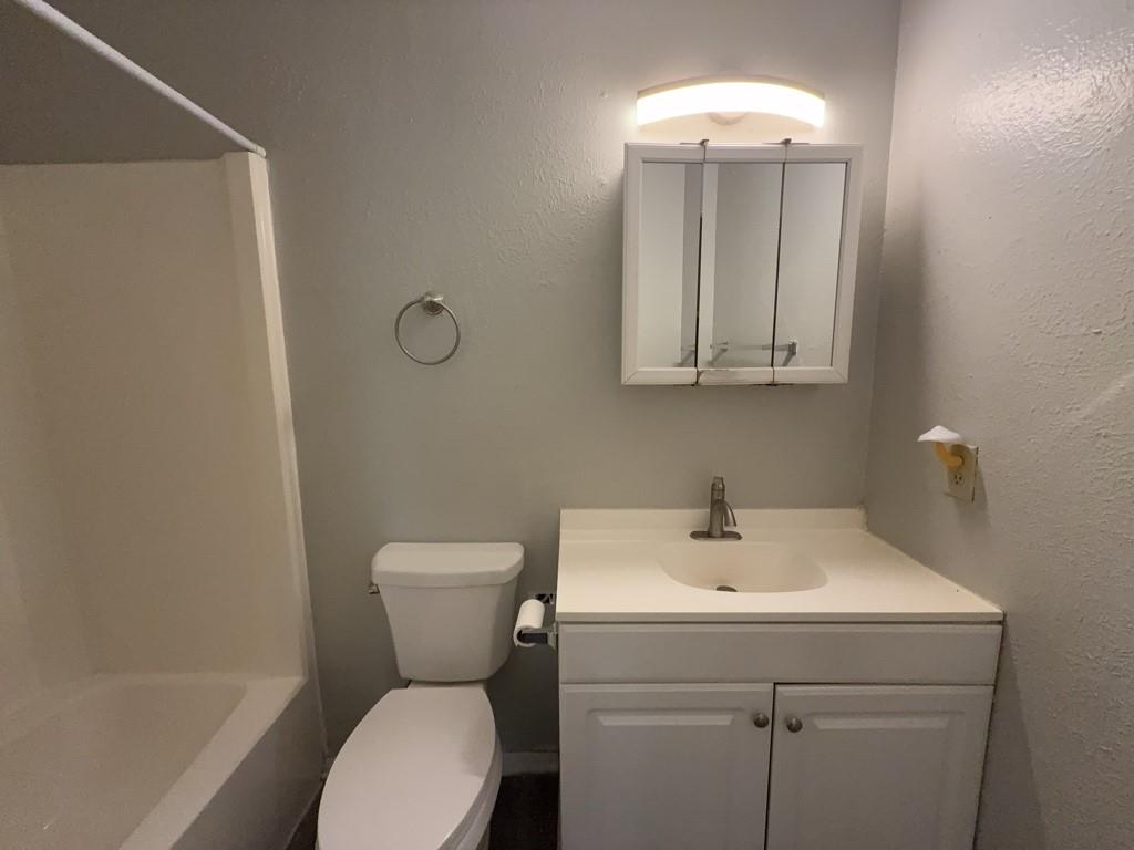 219 Fry Street, Unit 6 Denton, TX 76201 - Photo 10 of 13 a bathroom with a toilet sink and mirror