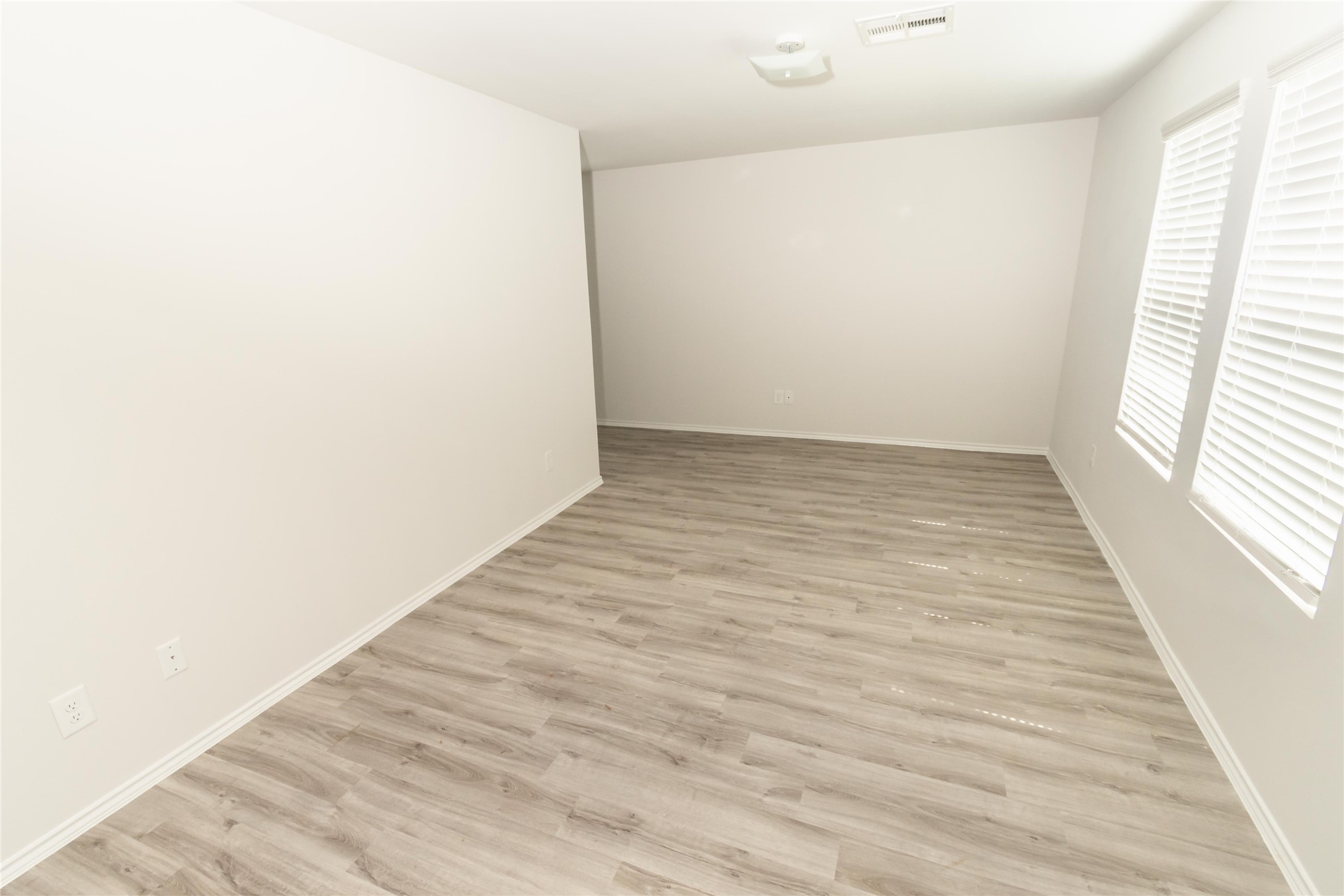 18638 Bell Ravine Drive Katy, TX 77449 - Photo 13 of 19 an empty room with wooden floor and windows