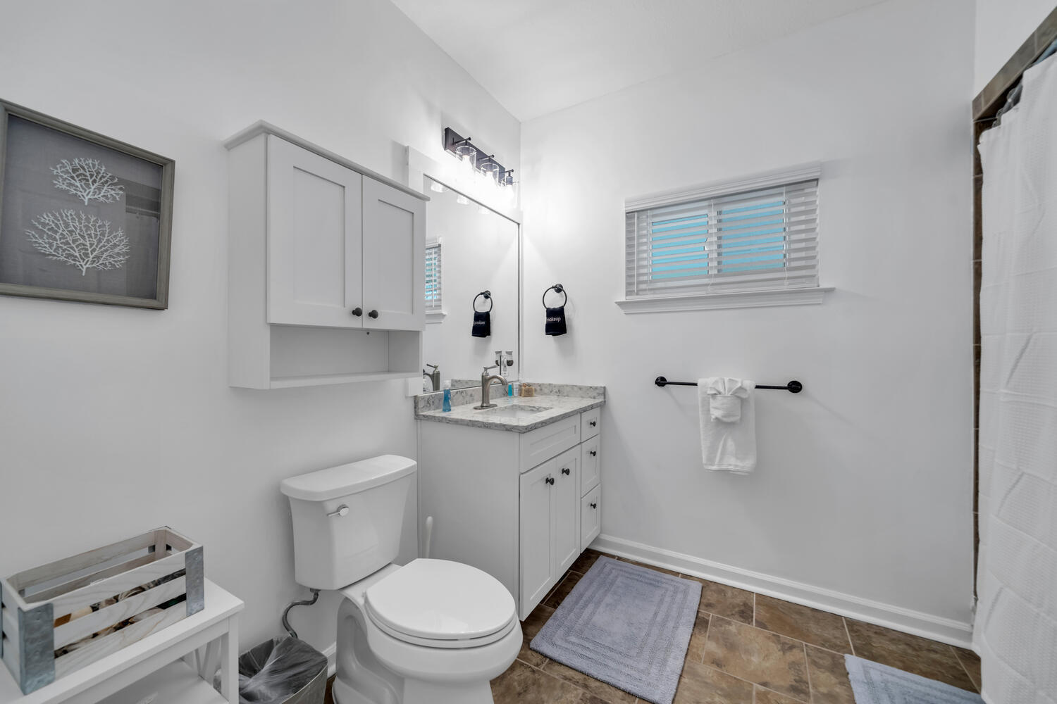 17878 Front Beach Road, Unit A1 Panama City Beach, FL 32413 - Photo 33 of 42 a bathroom with a toilet a sink and mirror