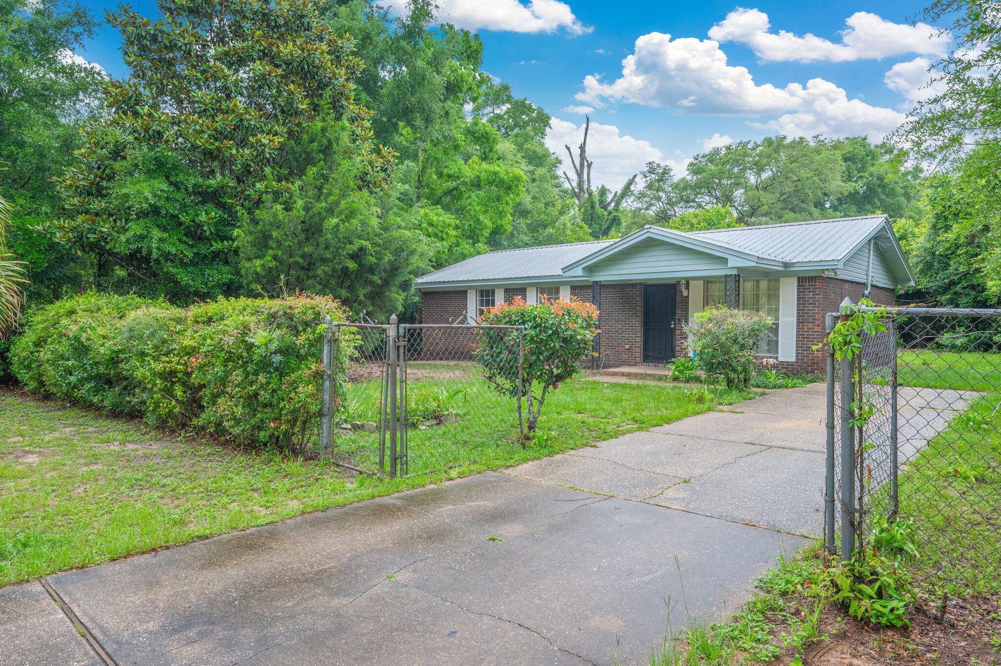 834 McDonald Street Crestview, FL 32536 - Photo 27 of 35 a front view of a house with a yard and potted plants