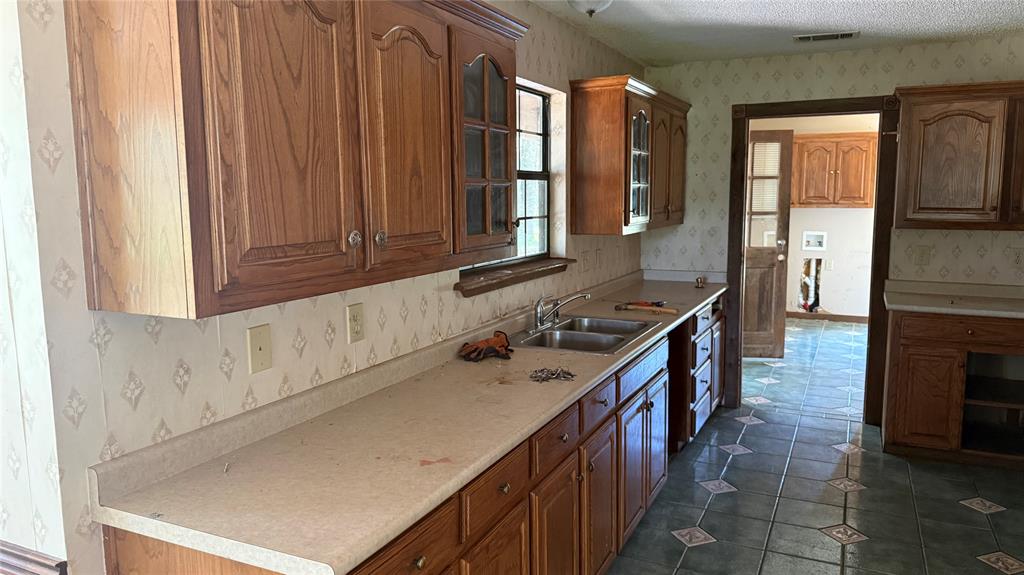 6582 Taylor Road Kaufman, TX 75142 - Photo 17 of 40 a kitchen with a sink stove and cabinets