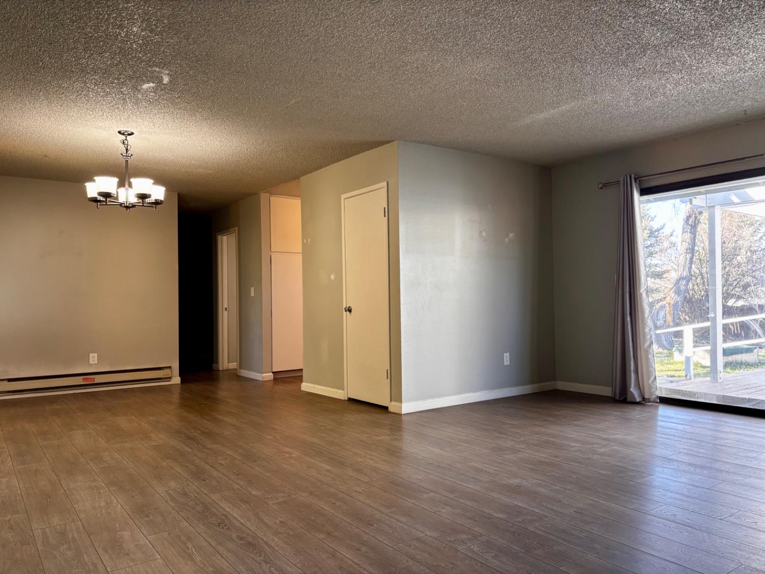 111 Patterson Avenue Loyalton, CA 96118 - Photo 14 of 46 an empty room with wooden floor and windows