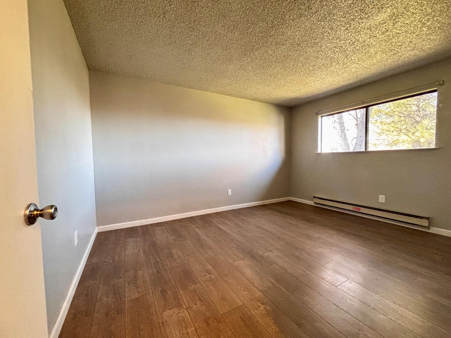 111 Patterson Avenue Loyalton, CA 96118 - Photo 26 of 46 an empty room with wooden floor and windows