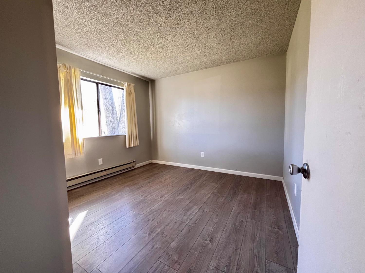 111 Patterson Avenue Loyalton, CA 96118 - Photo 30 of 45 an empty room with wooden floor and windows