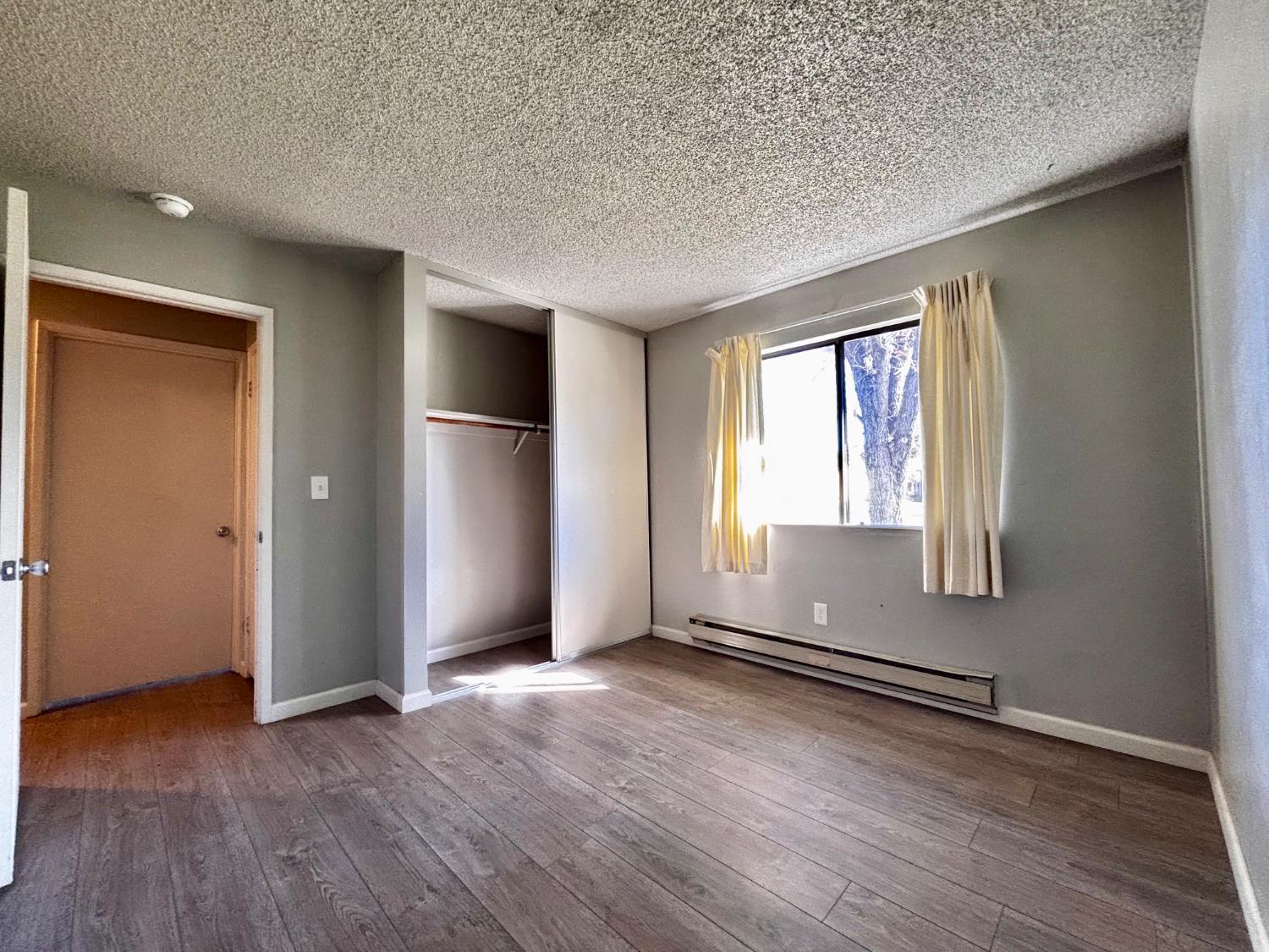 111 Patterson Avenue Loyalton, CA 96118 - Photo 32 of 46 an empty room with wooden floor and windows