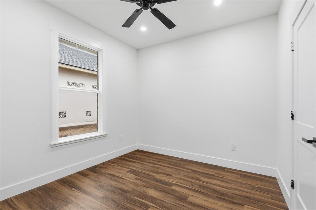 1413 Ridgeview Circle Granbury, TX 76048 - Photo 13 of 35 Room featuring wood-finish flooring, a white window frame, white walls, and a ceiling fan with integrated lighting