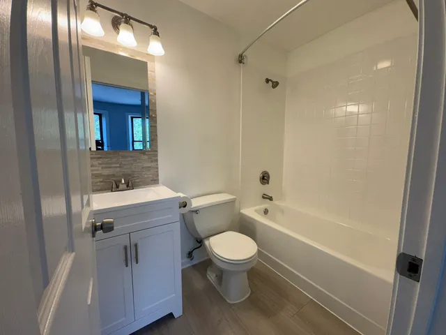 a bathroom with a granite countertop toilet a sink and bathtub