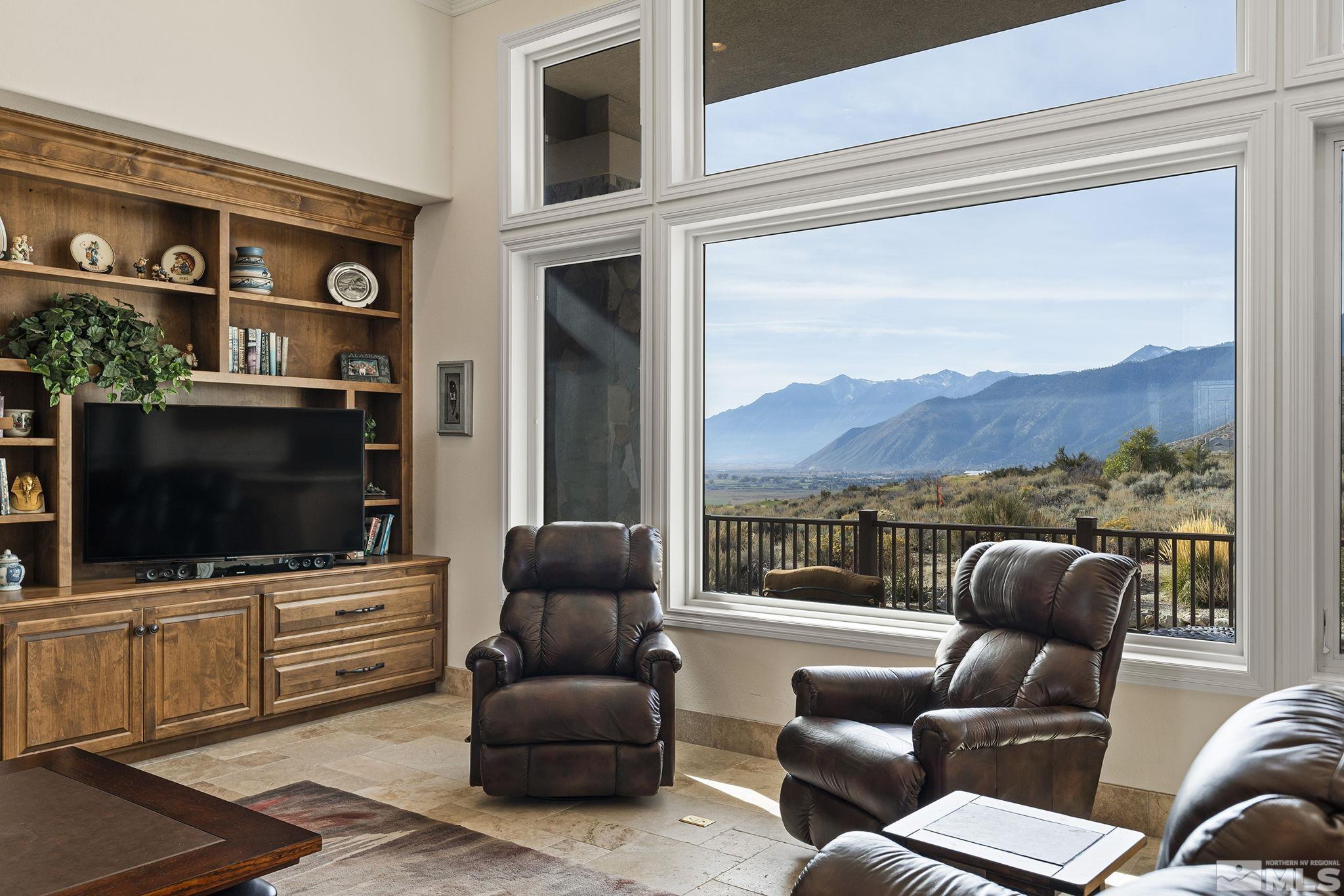 345 James Canyon Loop Genoa, NV 89411 - Photo 12 of 40 a living room with furniture a flat screen tv and a floor to ceiling window