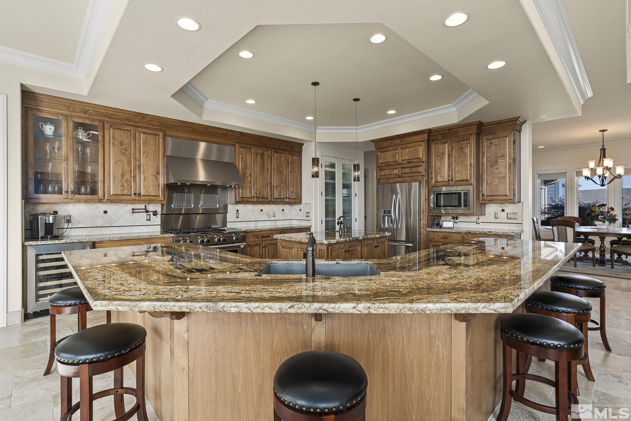 345 James Canyon Loop Genoa, NV 89411 - Photo 16 of 40 a kitchen with kitchen island granite countertop a sink and a refrigerator