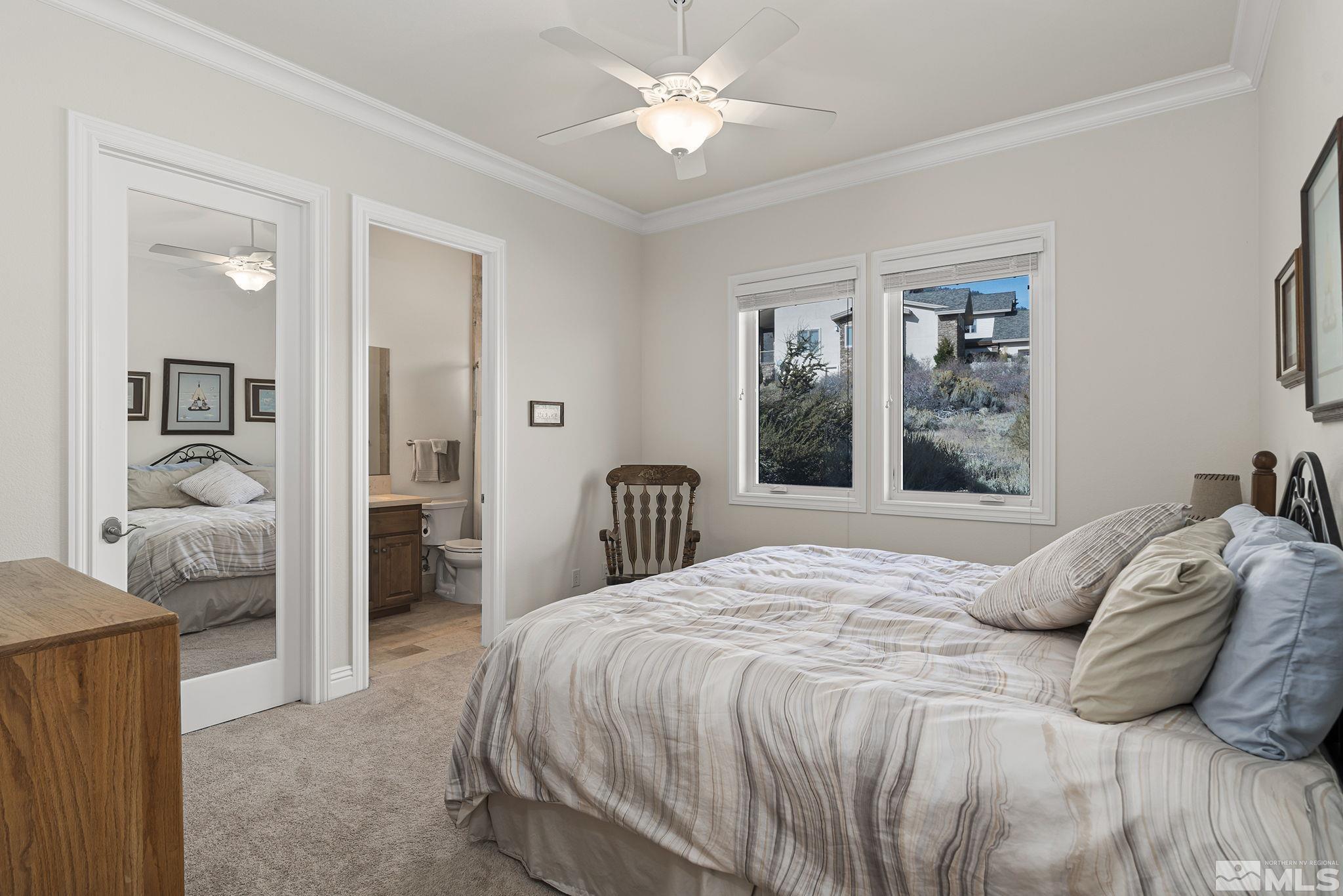345 James Canyon Loop Genoa, NV 89411 - Photo 26 of 40 a bedroom with a large bed and a chandelier