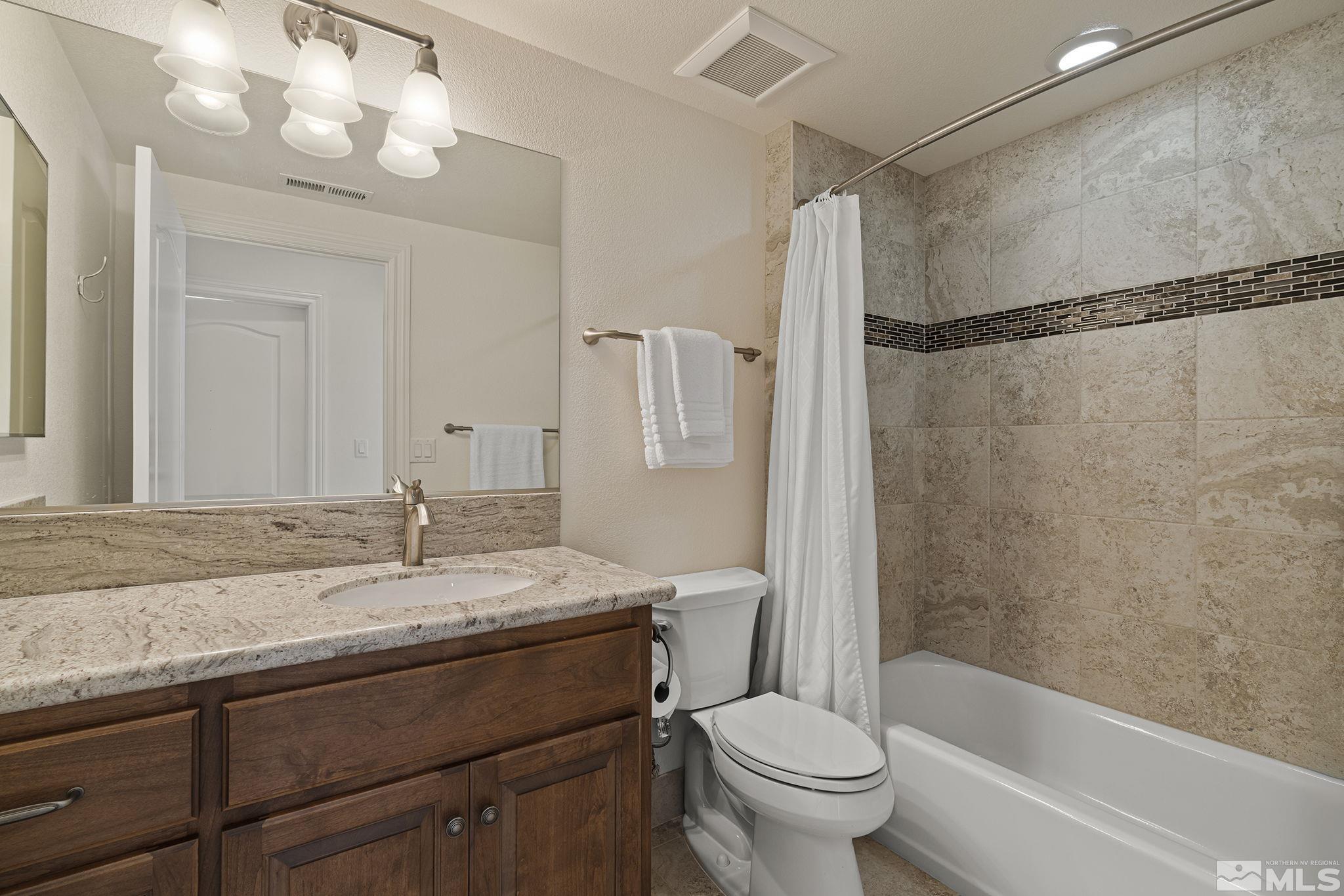 345 James Canyon Loop Genoa, NV 89411 - Photo 32 of 40 a bathroom with a granite countertop sink a toilet and shower