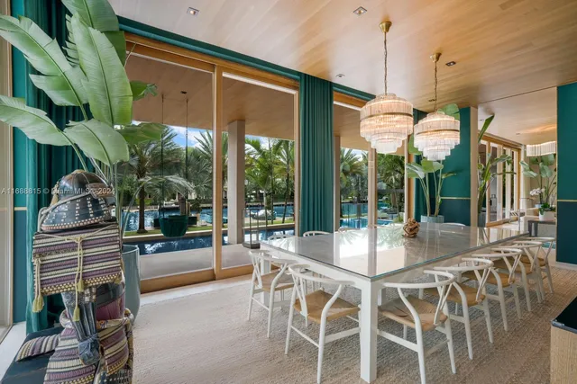 a dining room with furniture large windows and a chandelier