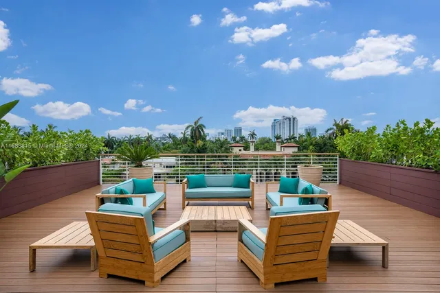 a view of a roof deck with couches and sky view
