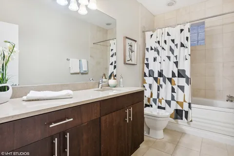 a bathroom with a double vanity sink toilet and shower
