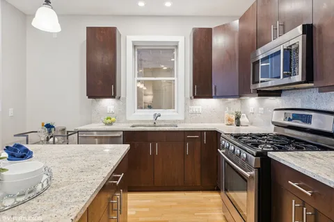 a kitchen with stainless steel appliances granite countertop a sink stove and cabinets