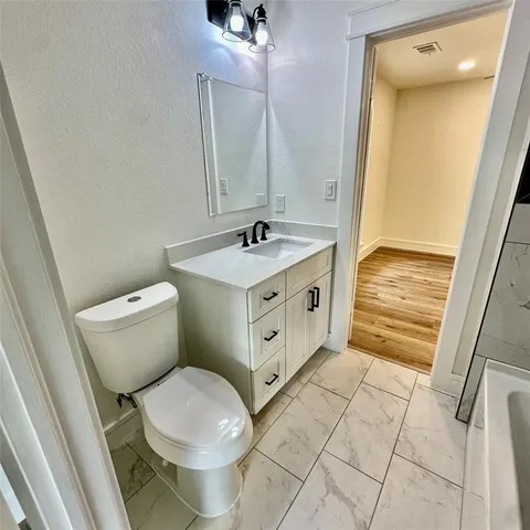 an empty room with wooden floor a ceiling fan and windows