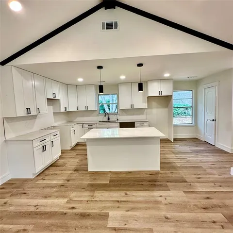 a large kitchen with stainless steel appliances granite countertop a stove a sink dishwasher and a refrigerator