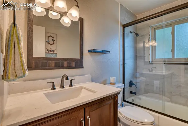 a bathroom with a sink a toilet a mirror and shower