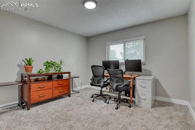 a view of a workspace with furniture and a window